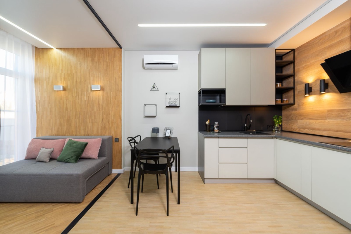 Best DIY 12,000 BTU mini split for 750 sq ft: open-plan studio with living area, dining table, and kitchen cooled by a single wall-mounted indoor unit