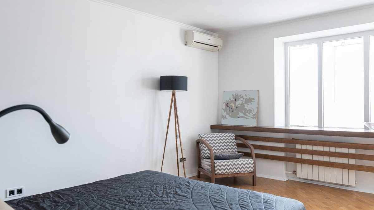White wall-mounted mini split indoor unit in a bedroom corner, helping manage mini split running cost per month efficiently