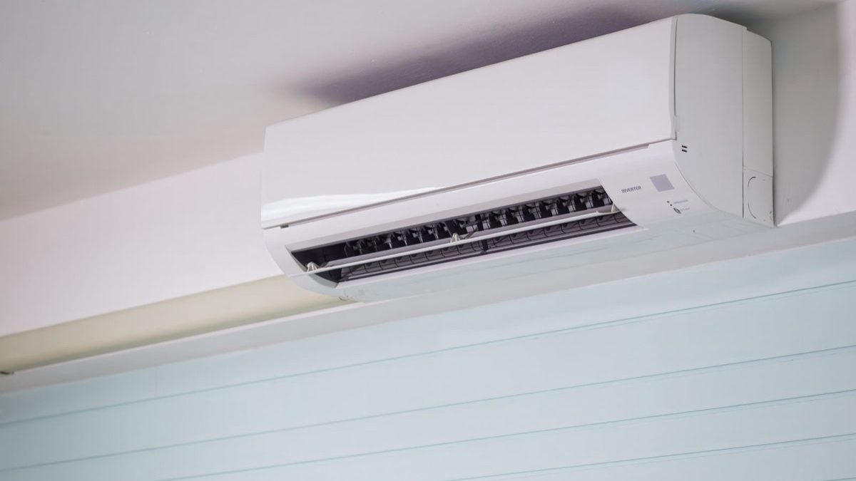 White wall-mounted mini split with open louver revealing vents and fan blades for cleaning a mini split diy